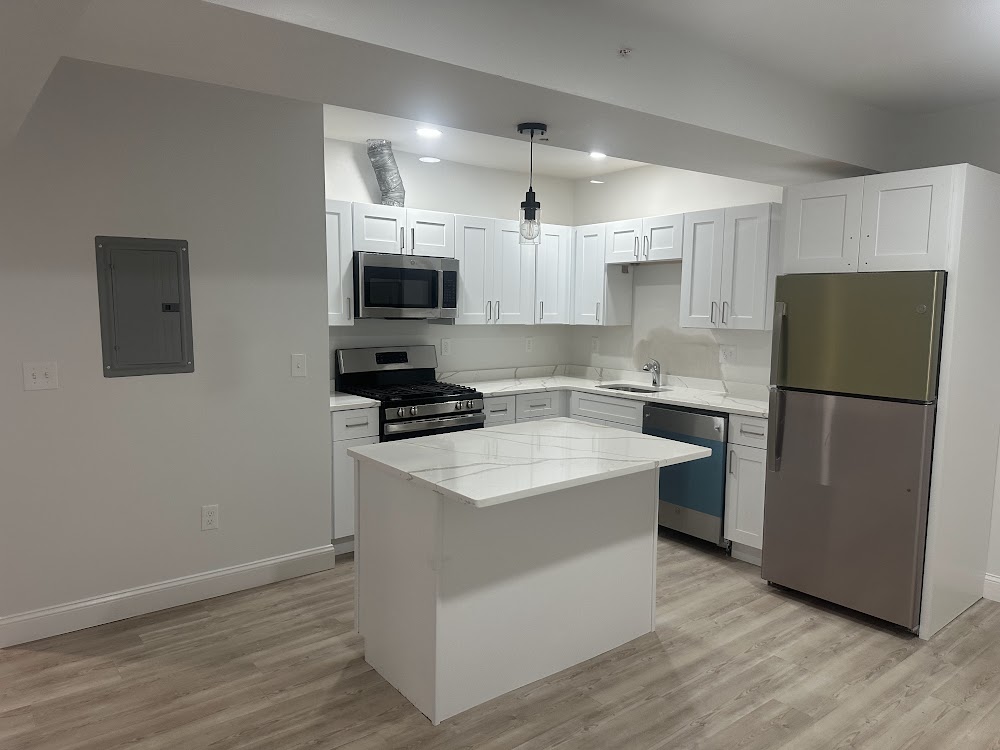 Kitchen with white cabinets, island, and wood-look flooring
